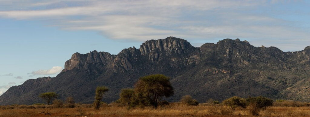 15 panel panorama of large mountainside within Tsavo West National Park, from the Rhino sanctuary.